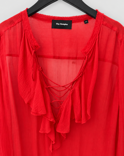 Detalle del escote cruzado de la blusa roja THE KOOPLES