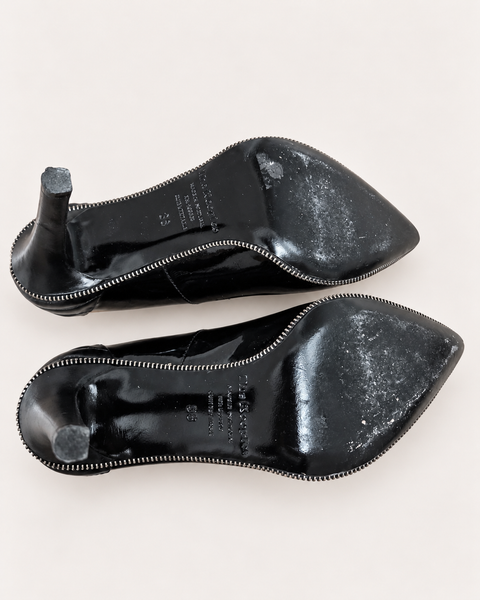 Vista de la parte inferior de las suelas de los tacones altos de cuero de charol negro, talla 38