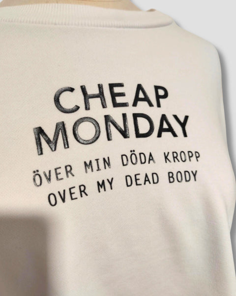 Detalle del logotipo Cheap Monday sobre sudadera blanca.